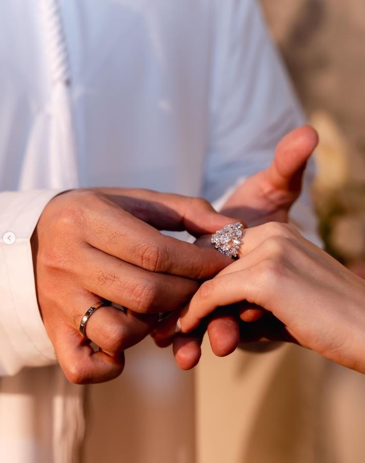 Groom placing the ring on the bride's hand